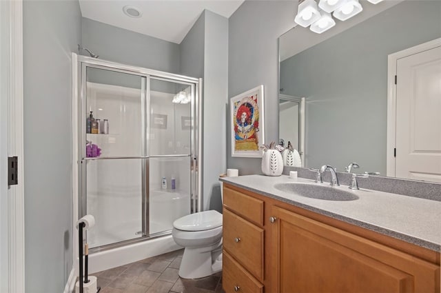 bathroom with vanity, a shower with shower door, and toilet