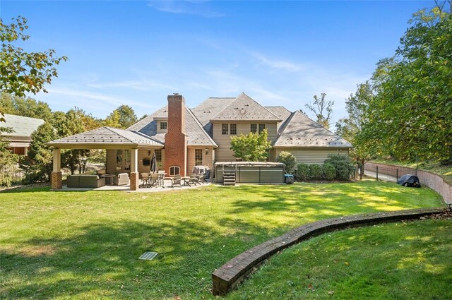 back of property featuring a patio, an outdoor living space, and a lawn