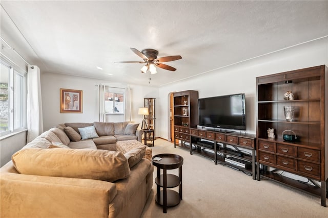 carpeted living room with ceiling fan and a textured ceiling