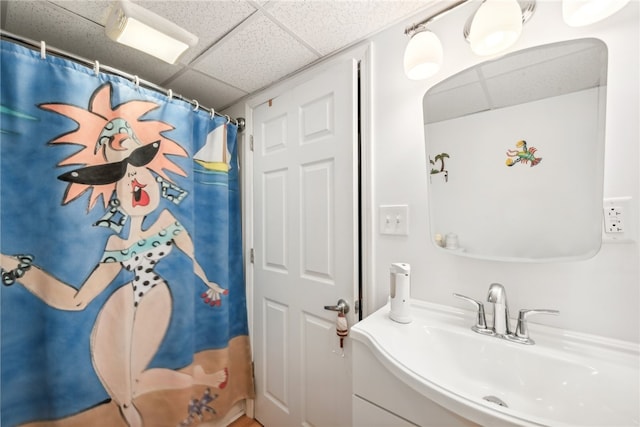 bathroom featuring a paneled ceiling, vanity, and curtained shower