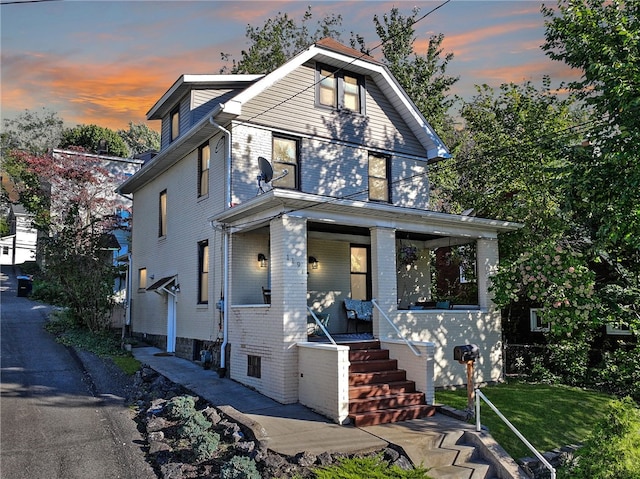 view of front facade featuring a porch and a yard