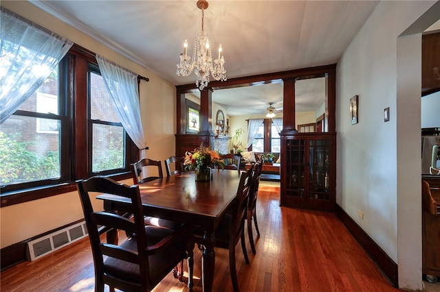 dining area with ceiling fan with notable chandelier and dark wood-type flooring