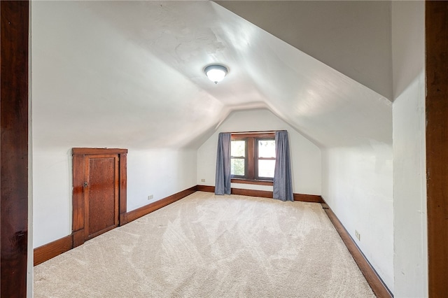 bonus room featuring lofted ceiling and light colored carpet