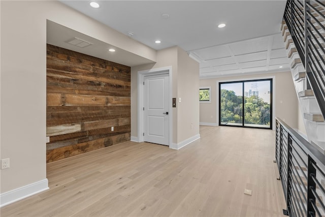 unfurnished living room featuring wood walls and light hardwood / wood-style floors