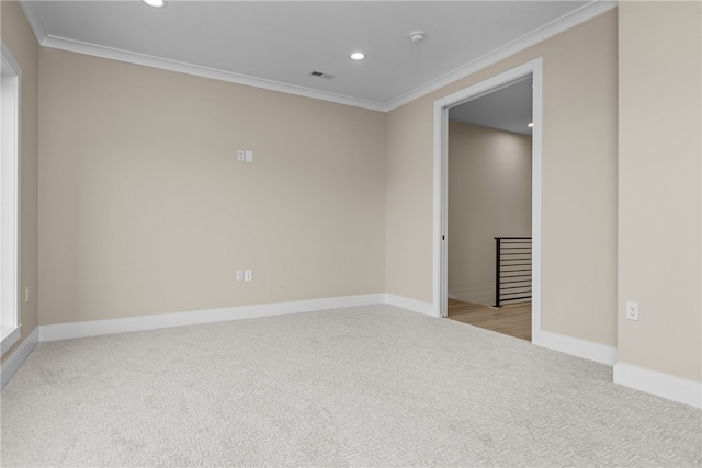 carpeted empty room featuring crown molding