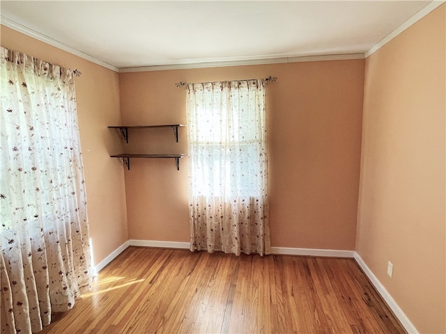 unfurnished room featuring light hardwood / wood-style floors and crown molding