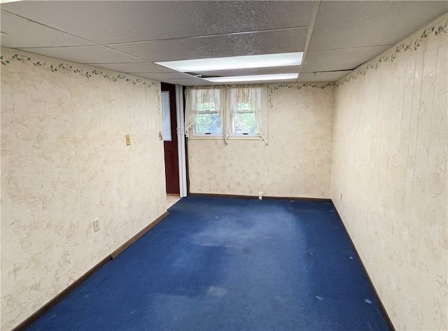 basement with a drop ceiling and carpet