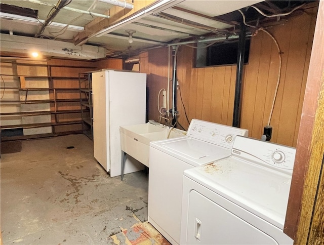 laundry area featuring wood walls and independent washer and dryer