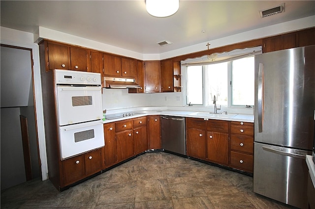 76 Broad St, West Bethlehem, PA 15345 - kitchen featuring a sink, brown cabinets, appliances with stainless steel finishes, light countertops, and under cabinet range hood