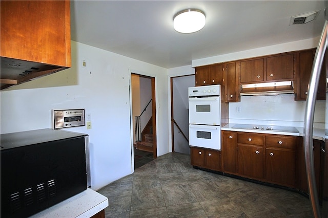 kitchen with dark brown cabinetry, double oven, and stovetop