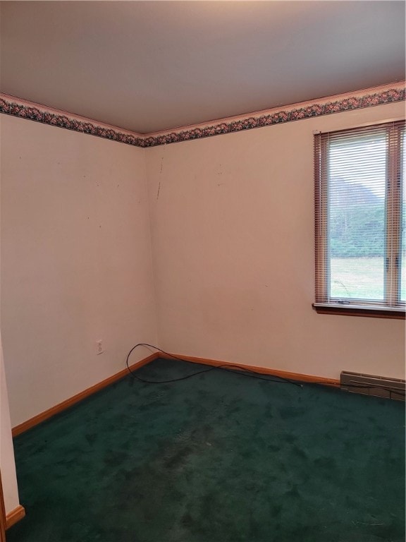 empty room featuring baseboard heating and carpet