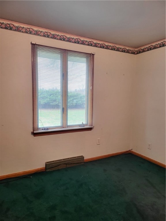 carpeted empty room with baseboard heating