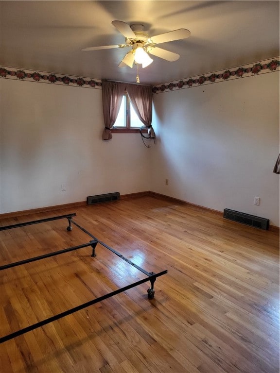 empty room with wood-type flooring and ceiling fan