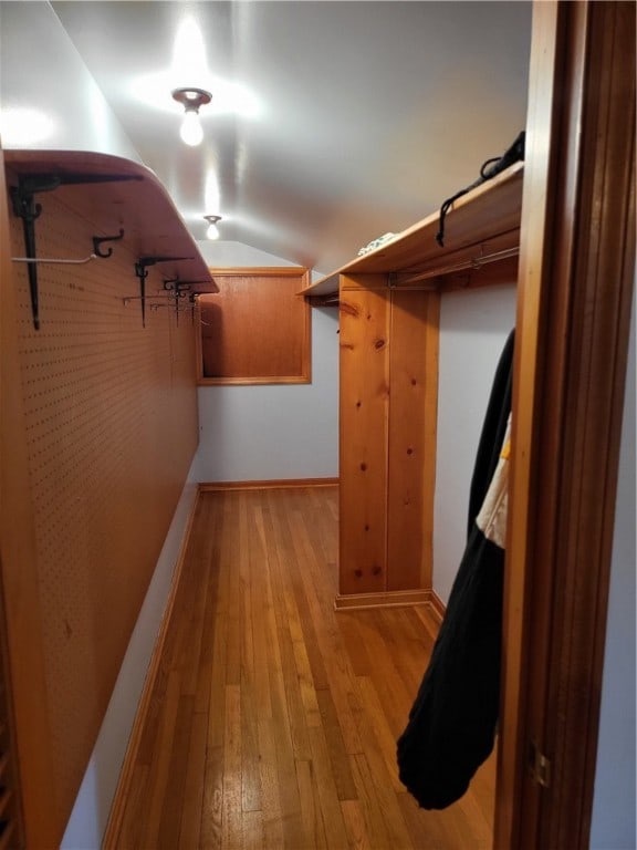 walk in closet featuring lofted ceiling and light hardwood / wood-style flooring