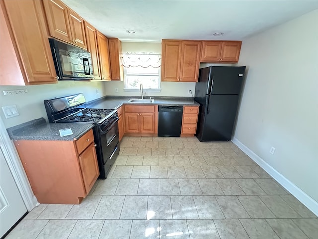 kitchen featuring light tile patterned flooring, black appliances, and sink