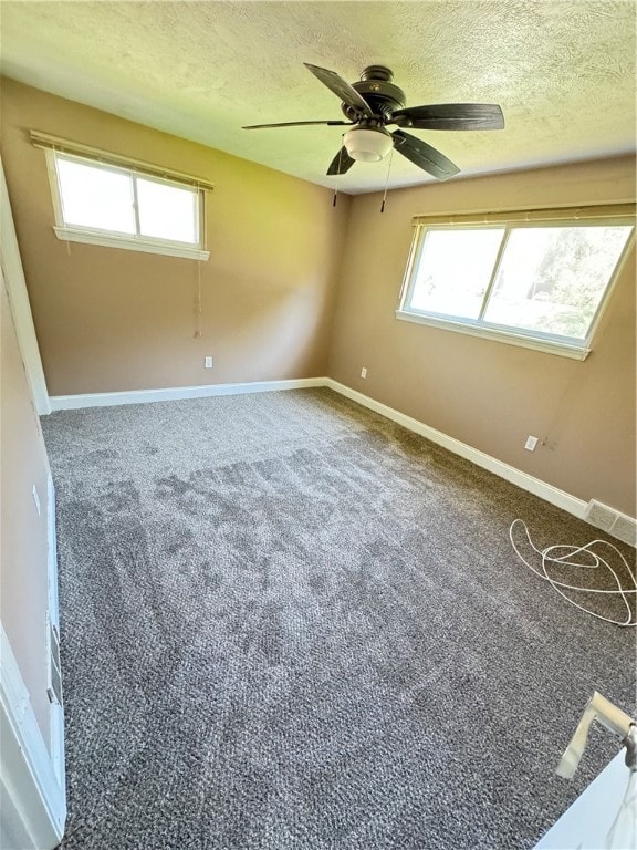 spare room with a textured ceiling, ceiling fan, and carpet flooring