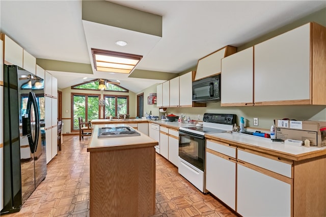 kitchen featuring lofted ceiling, kitchen peninsula, white cabinets, and black appliances