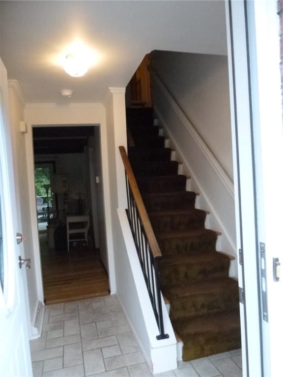 stairway featuring hardwood / wood-style flooring and ornamental molding