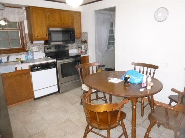 kitchen featuring stainless steel appliances, tasteful backsplash, sink, and light tile patterned floors