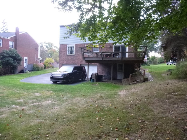 rear view of property featuring a wooden deck and a yard