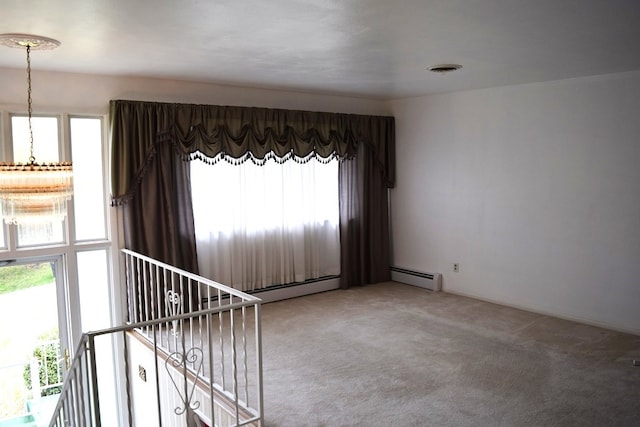 spare room featuring light colored carpet, a baseboard radiator, and plenty of natural light