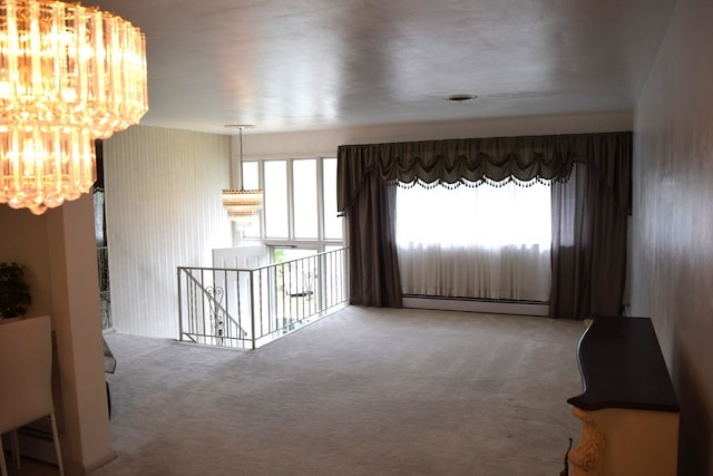 carpeted empty room featuring a wealth of natural light and a baseboard heating unit