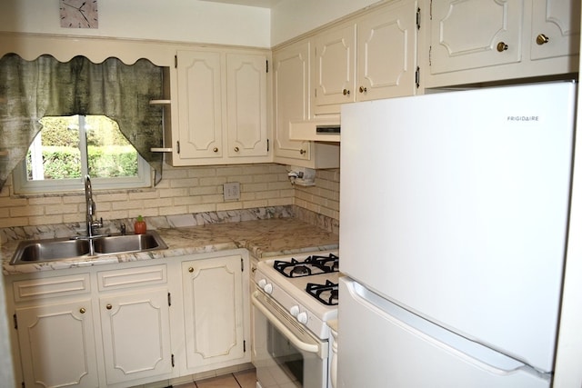 kitchen with white appliances, sink, decorative backsplash, white cabinets, and light tile patterned floors