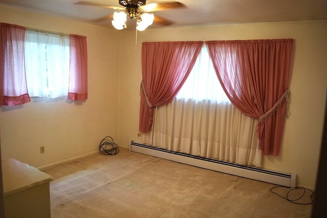 empty room with ceiling fan, carpet flooring, a baseboard heating unit, and a healthy amount of sunlight