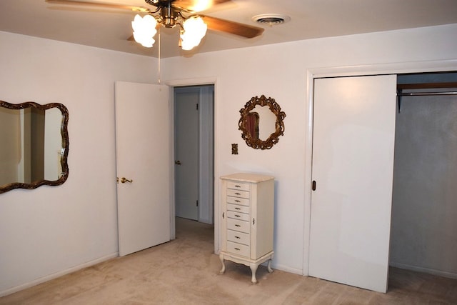 unfurnished bedroom with ceiling fan, a closet, and light carpet