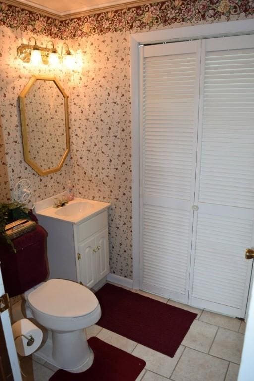 720 Pollard St, Monessen, PA 15062 - bathroom with crown molding, vanity, tile patterned floors, wallpapered walls, and a closet