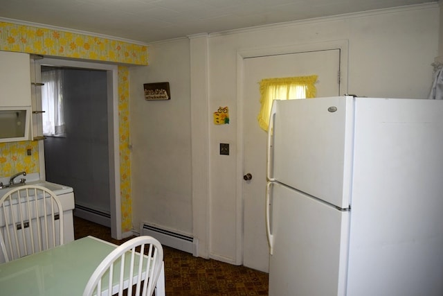 kitchen with white refrigerator, baseboard heating, and ornamental molding