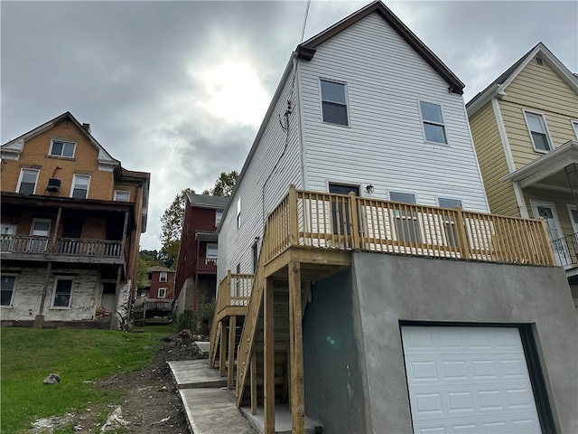 rear view of house featuring a yard, a balcony, and a garage