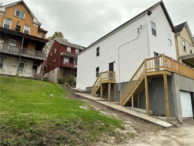 rear view of property featuring a garage and a lawn