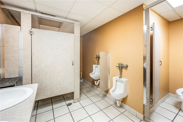 bathroom featuring vanity, a drop ceiling, tile patterned flooring, and toilet