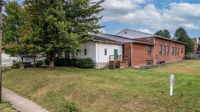 view of side of home featuring a yard and central AC