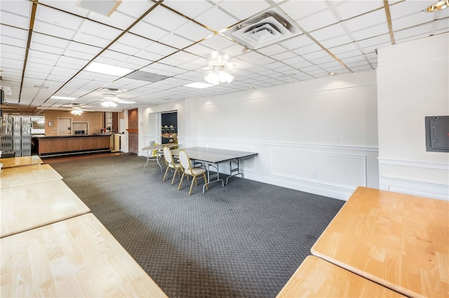 unfurnished dining area featuring ceiling fan and dark colored carpet