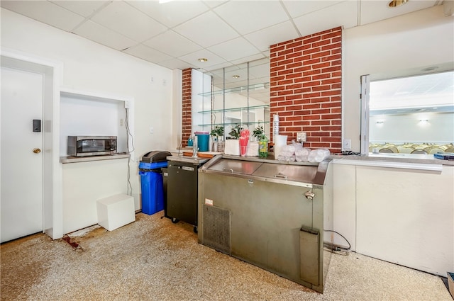 kitchen featuring light carpet and a paneled ceiling