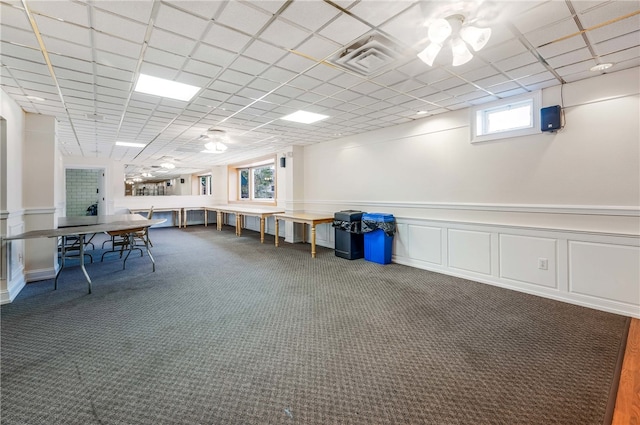 interior space with a drop ceiling and dark colored carpet