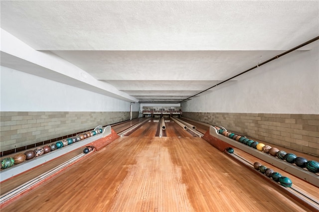 rec room featuring wood-type flooring and a textured ceiling