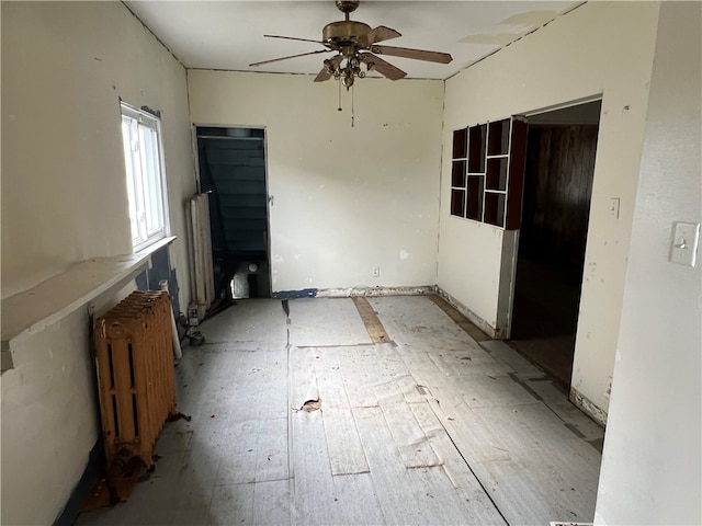 unfurnished room featuring ceiling fan and radiator heating unit