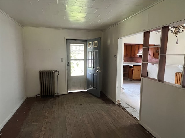 interior space featuring dark hardwood / wood-style floors, crown molding, and radiator