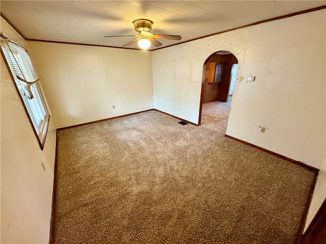 carpeted spare room with crown molding and ceiling fan