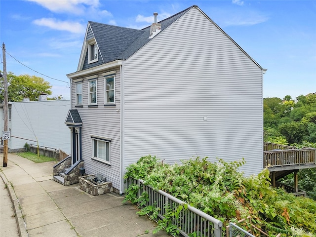 view of home's exterior featuring a wooden deck and a patio