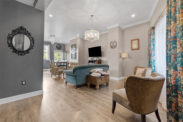 living room featuring light hardwood / wood-style floors, an inviting chandelier, and crown molding