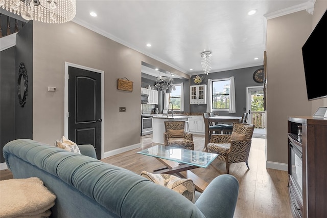 living room featuring an inviting chandelier, light hardwood / wood-style flooring, and ornamental molding