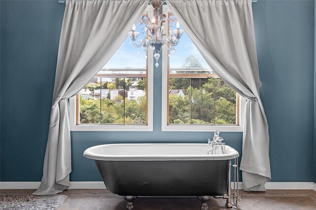 bathroom featuring a tub to relax in and an inviting chandelier