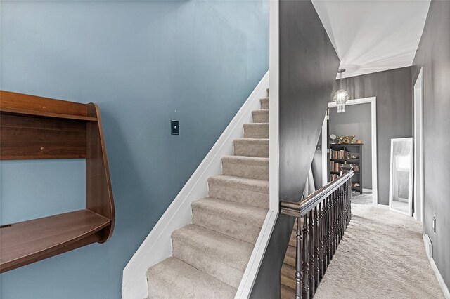 staircase featuring a towering ceiling and carpet