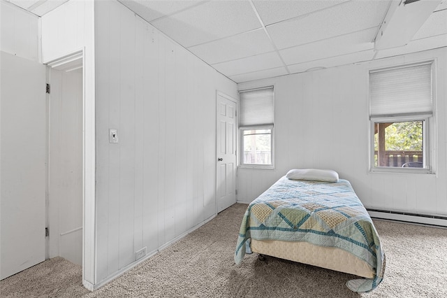 bedroom featuring carpet flooring, a baseboard heating unit, and a drop ceiling