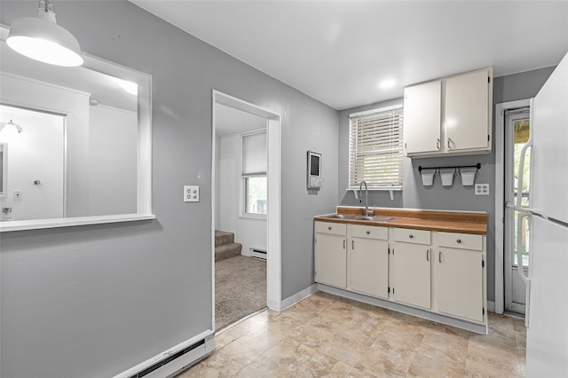 kitchen featuring light colored carpet, white cabinetry, sink, and a baseboard heating unit