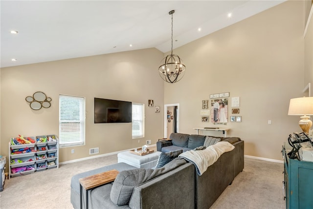 carpeted living room with high vaulted ceiling and an inviting chandelier